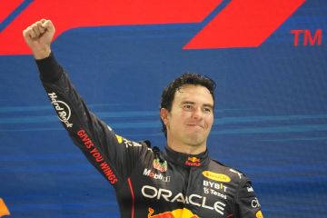 Red Bull driver Sergio Perez of Mexico celebrates on the podium after winning the Singapore Formula One Grand Prix, at the Marina Bay City Circuit in Singapore, Sunday, Oct.2, 2022. (AP Photo/Vincent Thian)